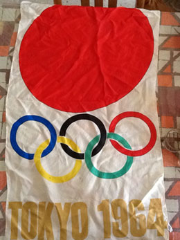 1964年東京オリンピック出場の際にヤマネ氏が使用しエリトリアに持ち帰った日の丸と五輪を配した旗。現在もエリトリアでヤマネ氏が大事に保管している。